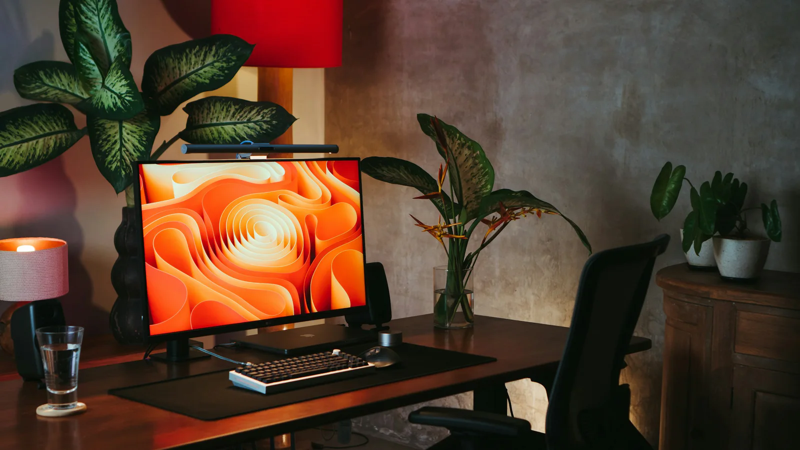 Bright Bali workspace with a laptop, monitor, desk, and greenery outside